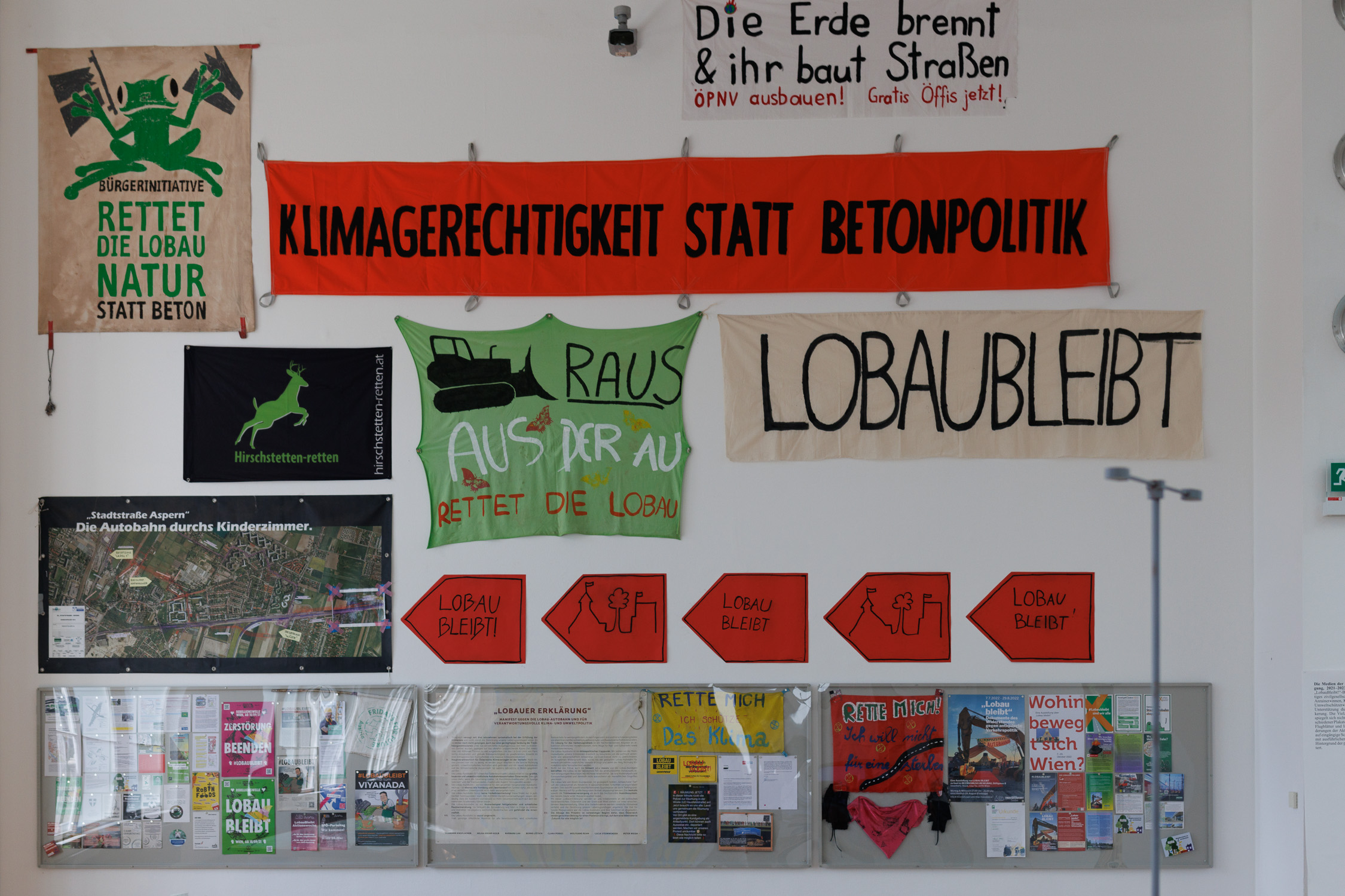 Protest banners are displayed on a wall in a museum exhibition.